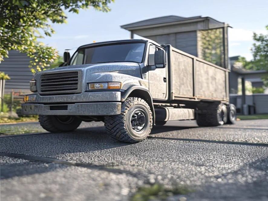 Cracked asphalt driveway with tire ruts left by a heavy delivery truck